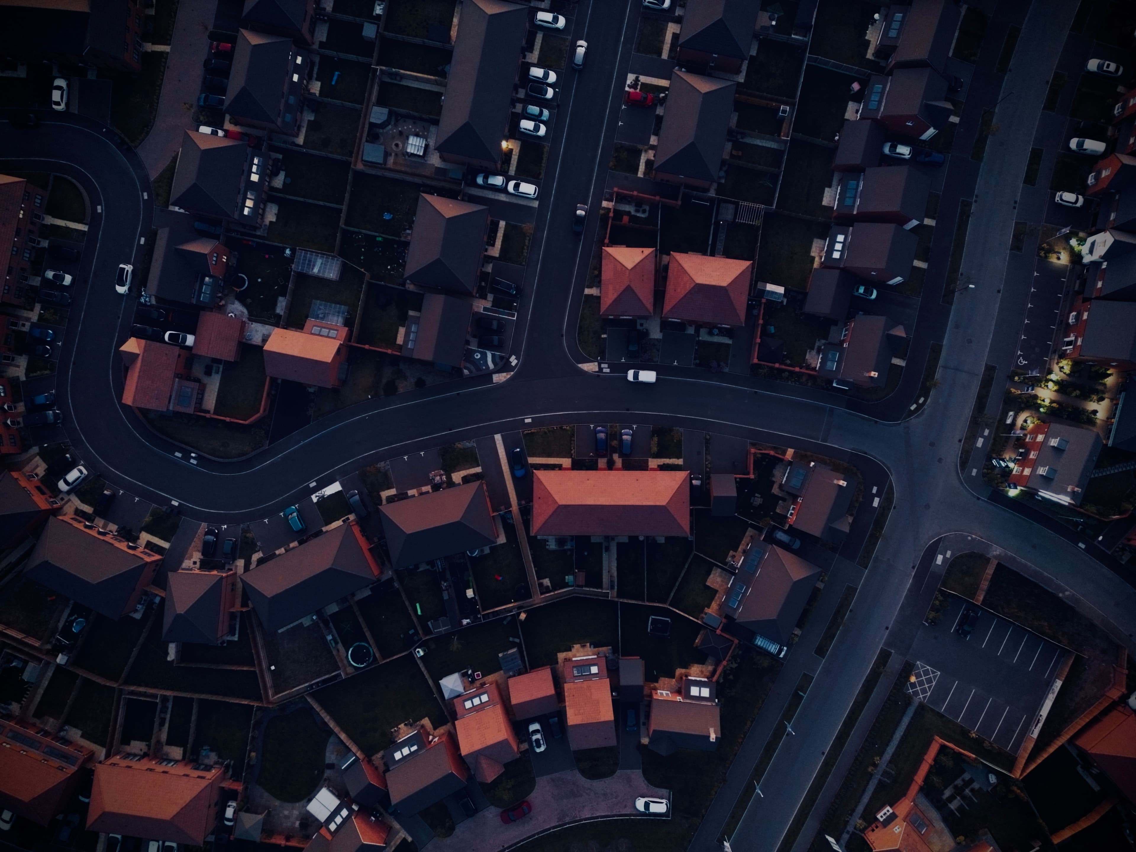Aerial view of a housing development at dusk with only a few lights on